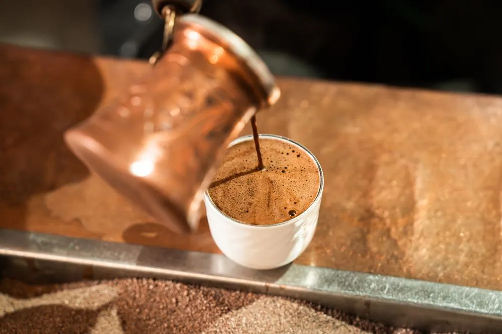 Arabic coffee poured from a brass dallah